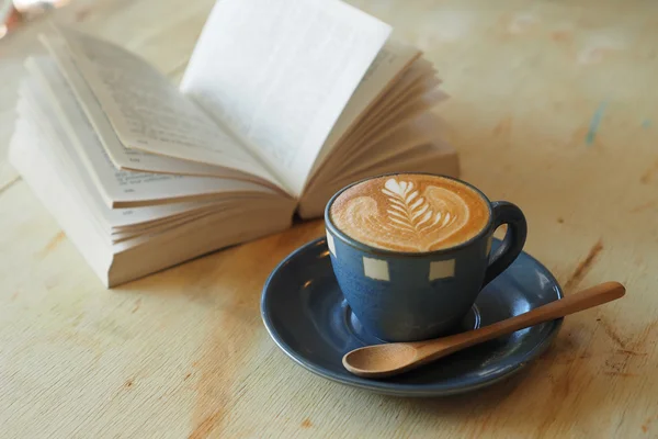 Чашка кофе с книгой в винтажном цвете кафе — стоковое фото