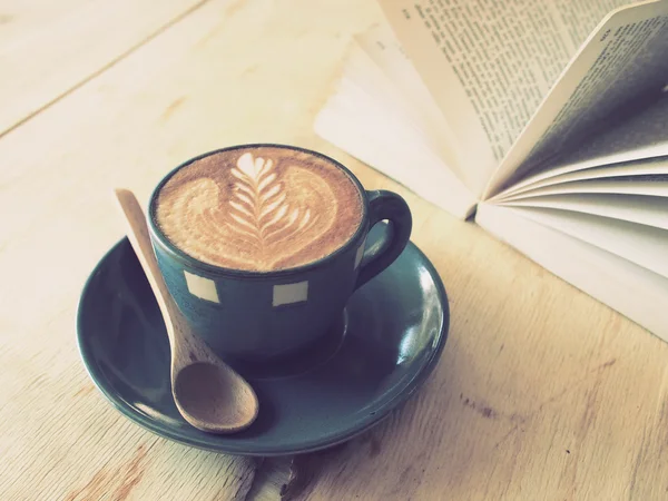 Tazza di caffè con libro in caffetteria colore vintage — Foto Stock