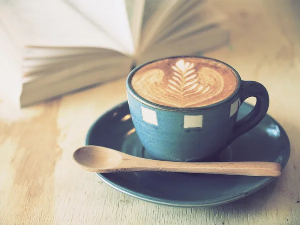 Tazza di caffè con libro in caffetteria colore vintage — Foto Stock