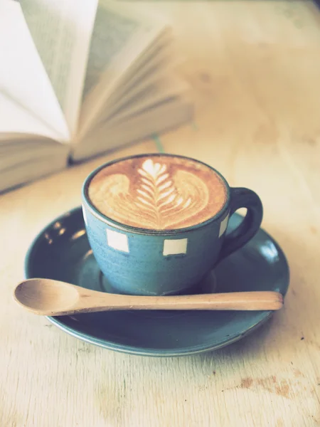 Kop kaffe med bog i kaffebar vintage farve - Stock-foto