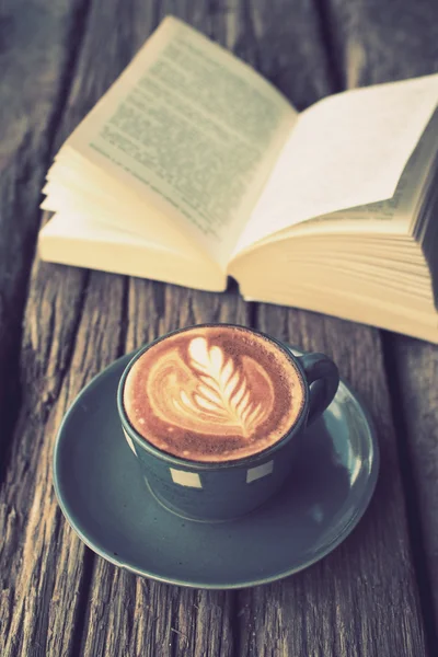 Tasse Kaffee Latte Art auf dem Holztisch und Buch in Vintage-Col — Stockfoto