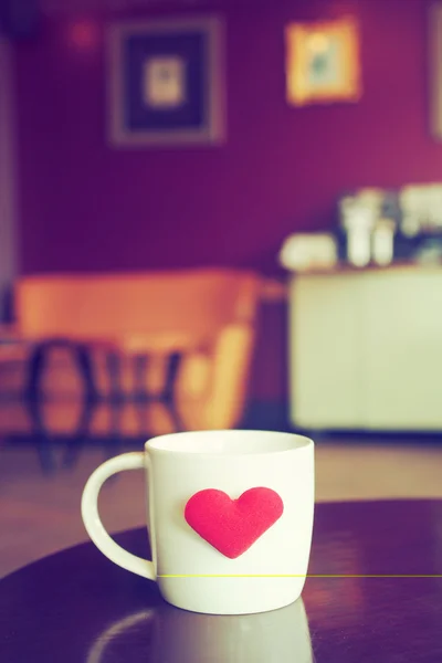 Tono de color vintage de la taza de café con el corazón rojo en la mesa — Foto de Stock