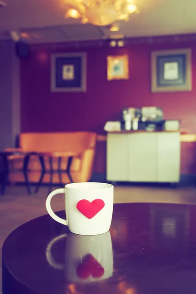 Vintage odcień filiżanki kawy z czerwonym sercem na stole — Zdjęcie stockowe