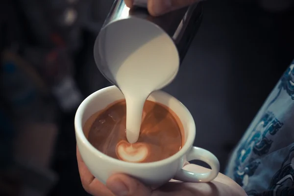 Kopje koffie latte kunst op de houten achtergrond in vintage kleur — Stockfoto
