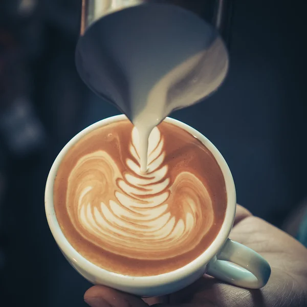 Šálek kávy latte art na dřevo pozadí barevně vinobraní — Stock fotografie