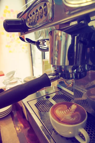 Kopp kaffe latte kunst på trebakgrunn i årgangsfarge – stockfoto
