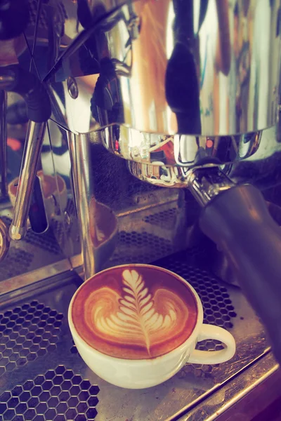 Šálek kávy latte art na dřevo pozadí barevně vinobraní — Stock fotografie