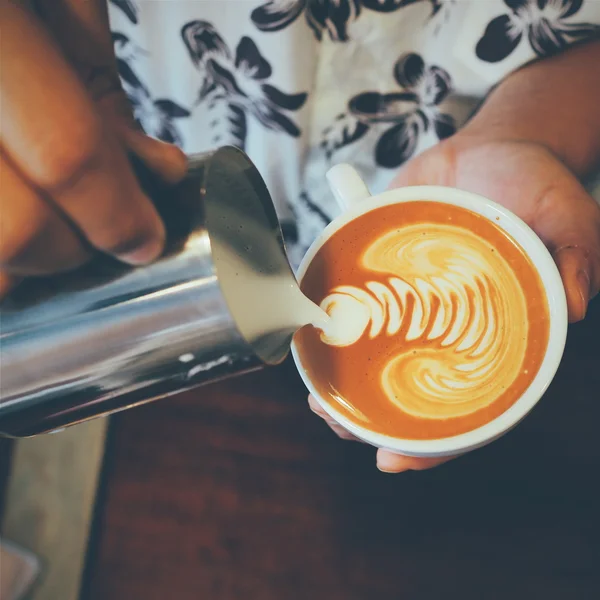 Cangkir kopi latte art pada latar belakang kayu dalam warna vintage — Stok Foto