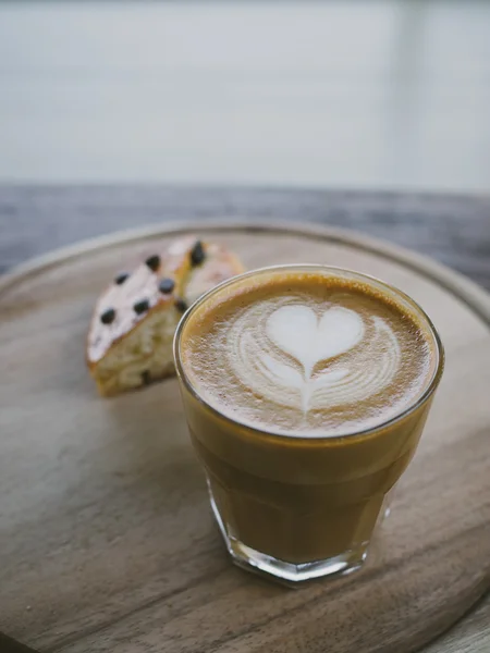 Csésze kávé latte art a fa íróasztal — Stock Fotó