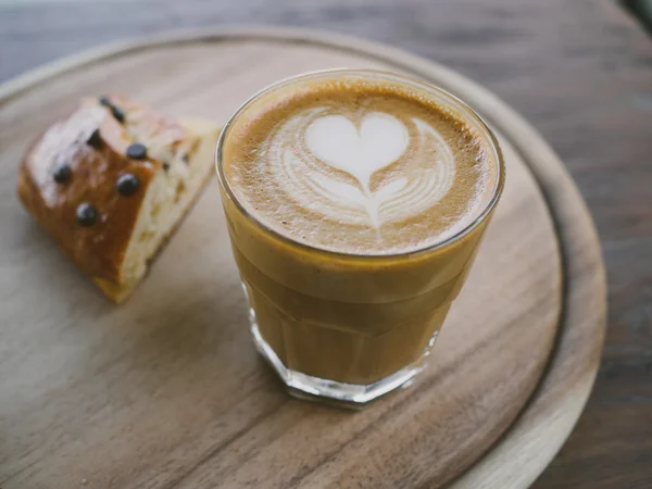 Csésze kávé latte art a fa íróasztal — Stock Fotó