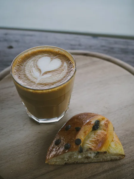 Tasse de café latte art sur le bureau en bois — Photo