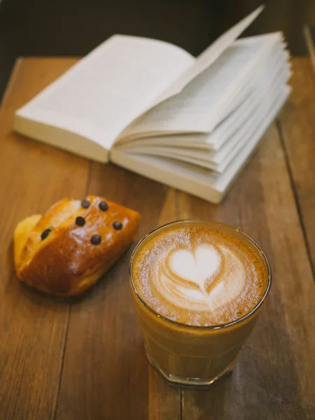 Csésze kávé latte art a fa íróasztal — Stock Fotó