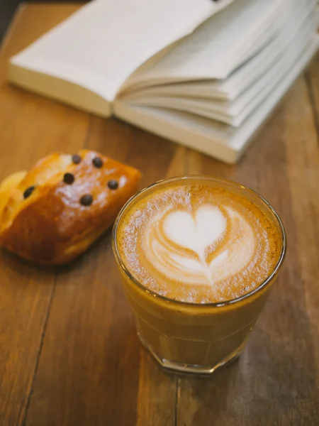 Filiżanka do kawy latte art na drewniane biurko — Zdjęcie stockowe