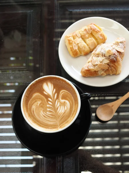 木製の机の上のコーヒー カフェラテ アートのカップ — ストック写真
