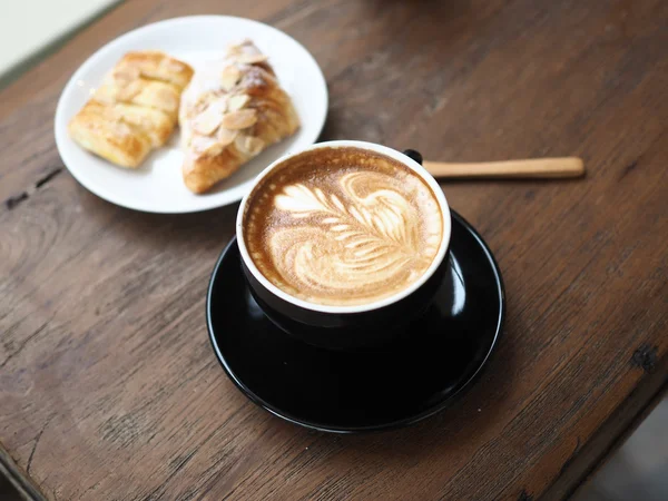 Tasse de café latte art sur le bureau en bois — Photo