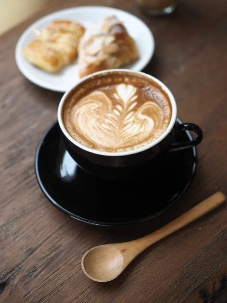 Tasse de café latte art sur le bureau en bois — Photo