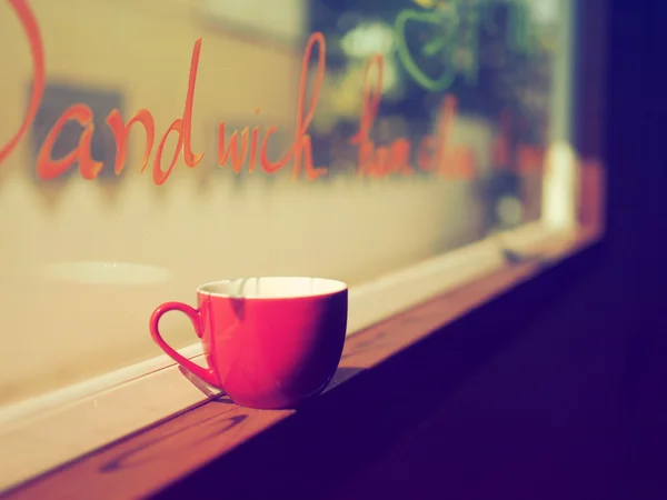 Чашка кофе на окне винтажный тон цвета — стоковое фото