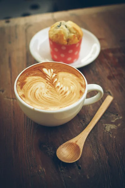 Tasse de café latte art sur le bureau en bois — Photo