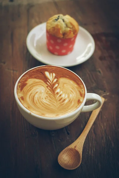 Tasse de café latte art sur le bureau en bois — Photo