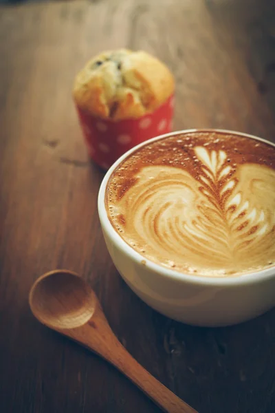 Tasse de café latte art sur le bureau en bois — Photo