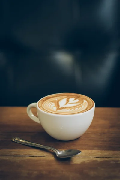 Koffie latte kunst op de houten bureau — Stockfoto