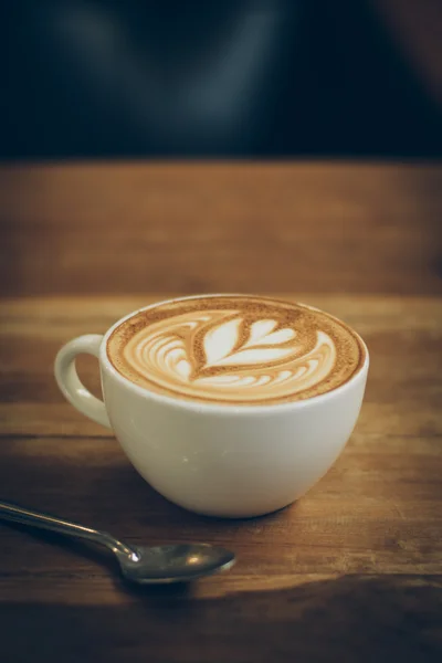 Koffie latte kunst op de houten bureau — Stockfoto