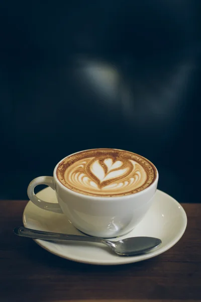 Coffee latte art on the wood desk — Stock Photo, Image