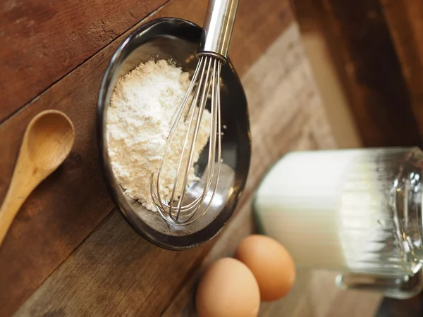 Baking cake ingredients. Bowl, flour, eggs on the wood desk — Stock Photo, Image