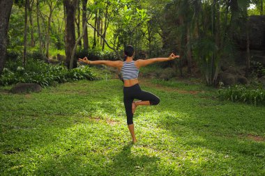 Genç kadının yoga egzersizleri Bahçe park yapması