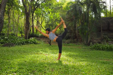 Genç kadının yoga egzersizleri Bahçe park yapması