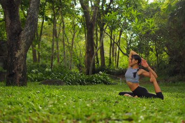 Genç kadının yoga egzersizleri Bahçe park yapması