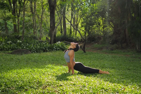 Jovem fazendo exercícios de ioga no parque do jardim — Fotografia de Stock