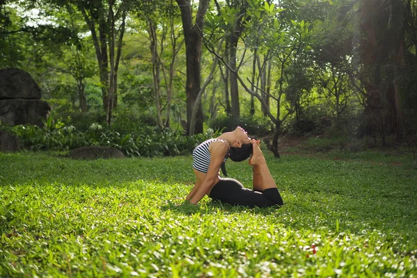 Jovem fazendo exercícios de ioga no parque do jardim — Fotografia de Stock