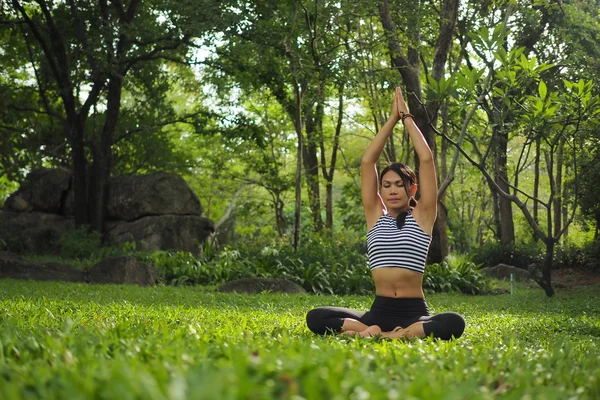 Mujer joven haciendo ejercicios de yoga en el parque del jardín — Foto de Stock