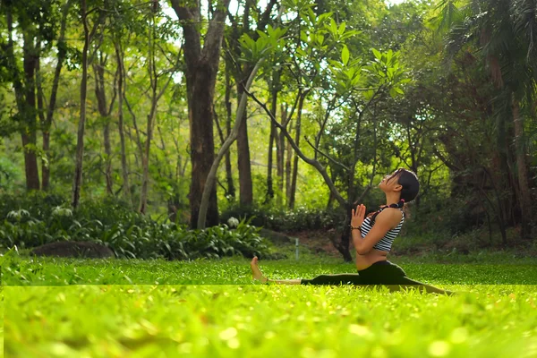 Νεαρή γυναίκα να κάνει ασκήσεις γιόγκα στο πάρκο κήπων — Φωτογραφία Αρχείου