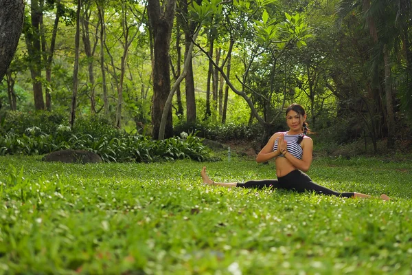 Mujer joven haciendo ejercicios de yoga en el parque del jardín — Foto de Stock