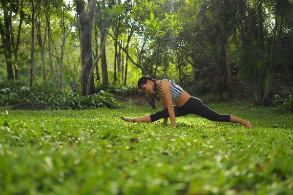 Mujer joven haciendo ejercicios de yoga en el parque del jardín — Foto de Stock