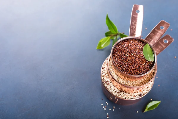 Pila di tre misurini in rame con quinoa cruda mista — Foto Stock