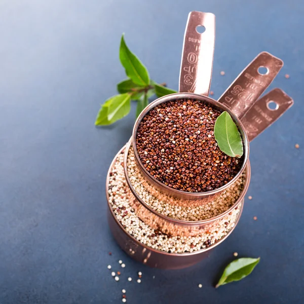 Pila di tre misurini in rame con quinoa cruda mista — Foto Stock