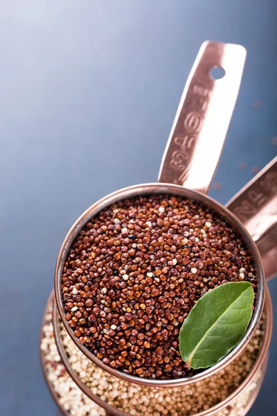 Pile de trois tasses à mesurer en cuivre avec du quinoa cru mélangé — Photo
