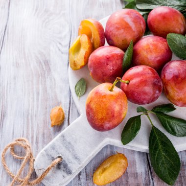 Mermer kesme tahtası üzerinde taze Erik