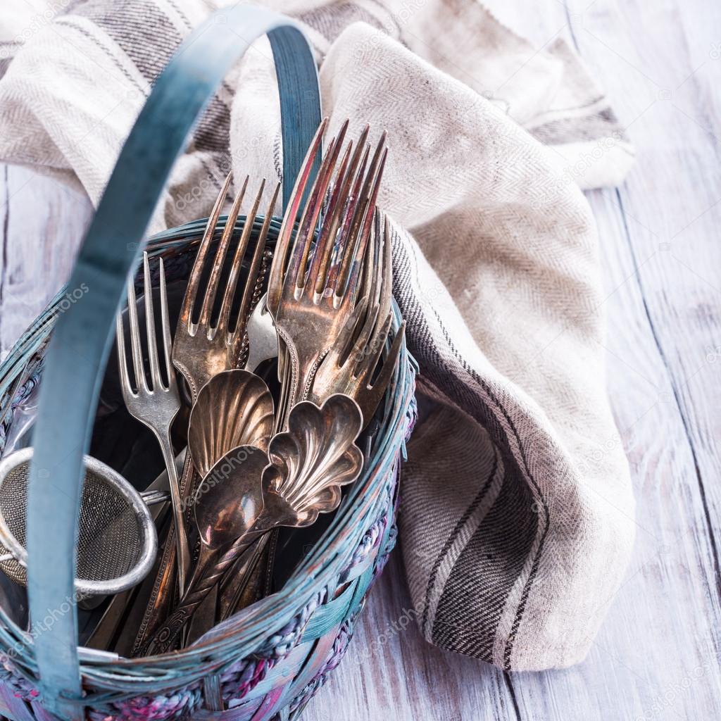 Vintage cutlery in old blue wicker basket