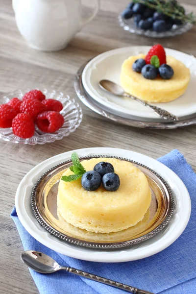 Leckeren Zitronenpudding Kuchen mit Beeren serviert — Stockfoto