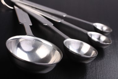 boş metal kaşık siyah arka plan üzerinde ölçüm