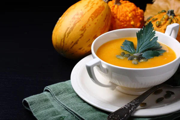 Pumpkin soup in white plate with celery leaves — Stock Photo, Image