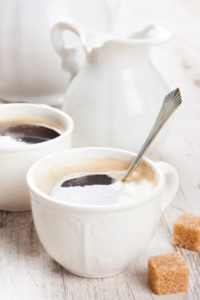 Xícara de café com filhotes de açúcar e jarro de leite — Fotografia de Stock