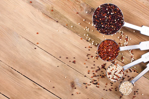 Mieszanka ziarna quinoa w metalu pomiaru łyżki — Zdjęcie stockowe