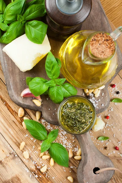 Pesto caseiro em uma tábua de corte de madeira rústica . — Fotografia de Stock