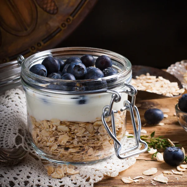 Muesli met yoghurt en blauwe bessen in glazen pot. — Stockfoto