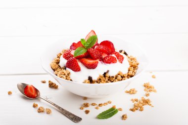 Fresh strawberries , yogurt and homemade granola